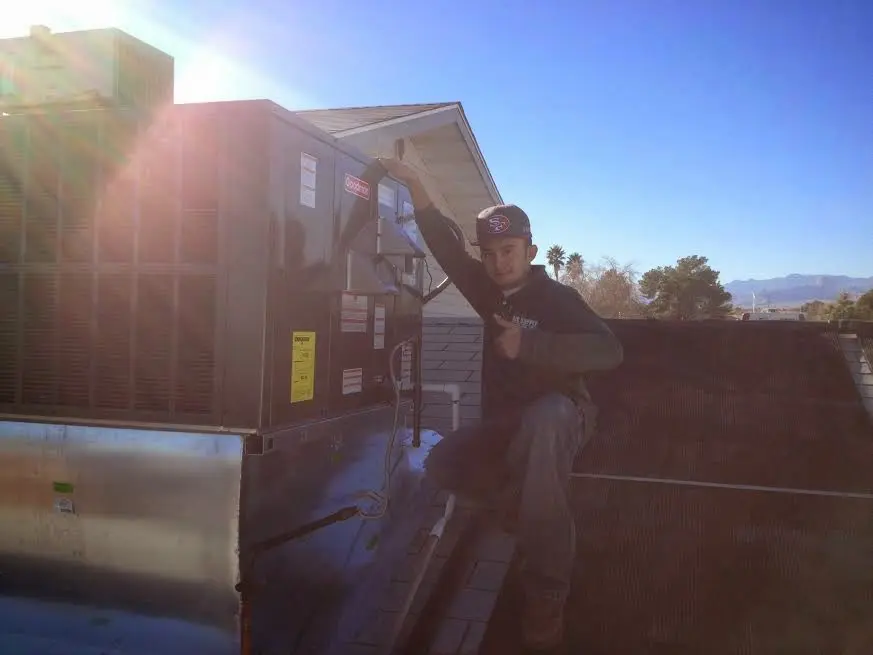 HVAC technician performing HVAC Inspection on a rooftop unit in Southwick